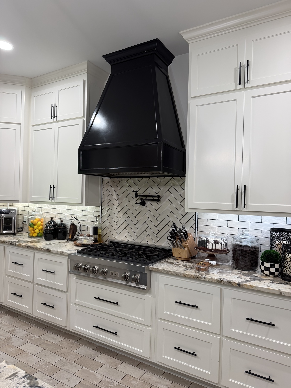 Clean white kitchen with black range hood